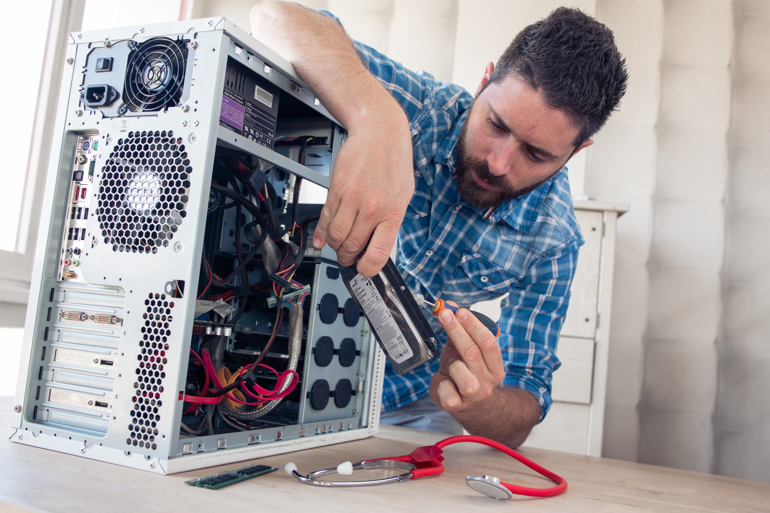 Das Bild zeigt einen Mann bei der Reparatur einer Festplatte.