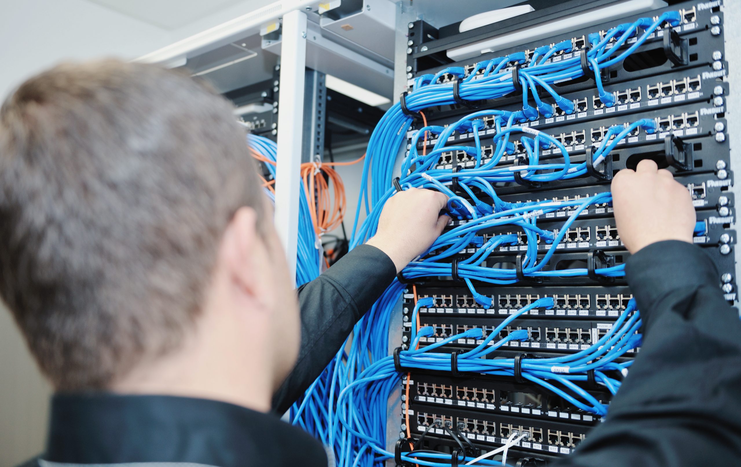 Das Bild zeigt einen Mann, bei der Arbeit an einem Server.